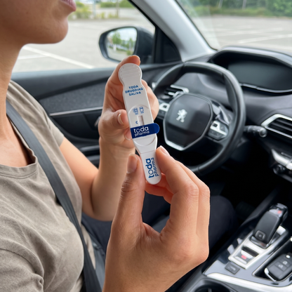 Jeune femme dans une voiture tenant un test salivaire THC Cannabis Drugdiag Saliva du laboratoire Toda Pharma